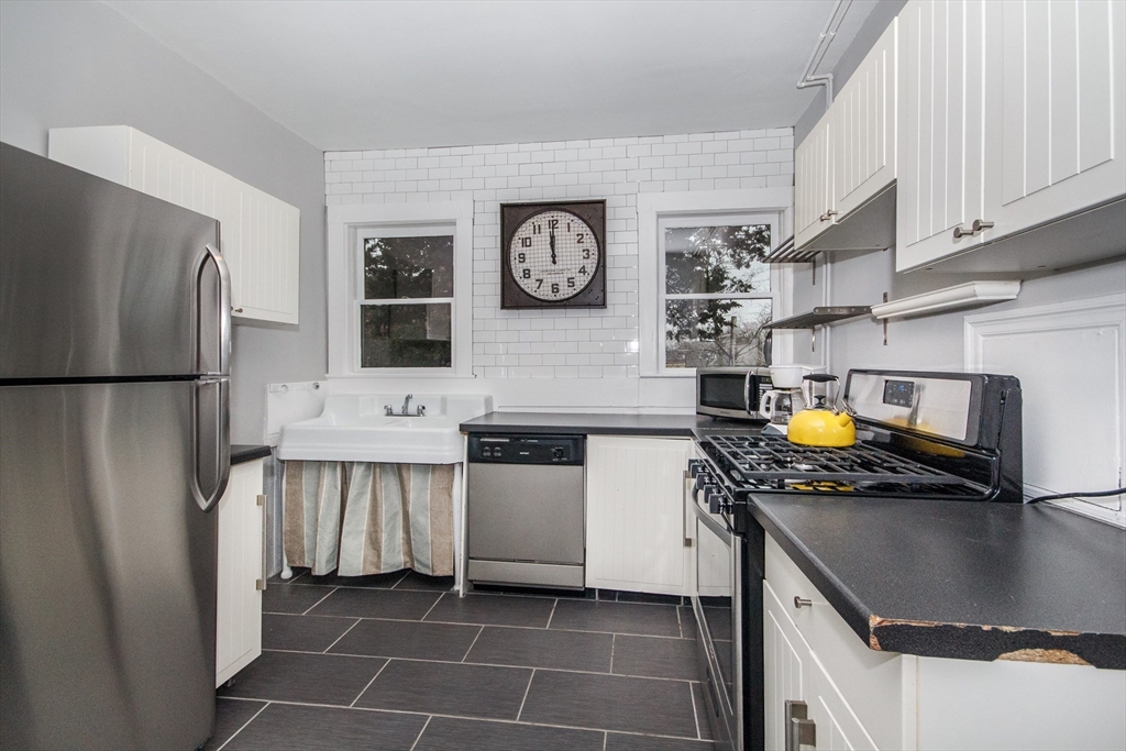 584 Centre Street Boston, MA 02130 - Photo 19 of 29 a kitchen with stainless steel appliances granite countertop a sink a stove and a refrigerator