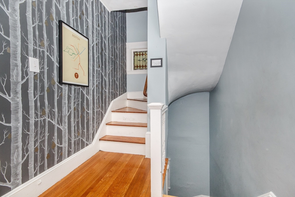 584 Centre Street Boston, MA 02130 - Photo 28 of 29 a view of a hallway with wooden floor and staircase
