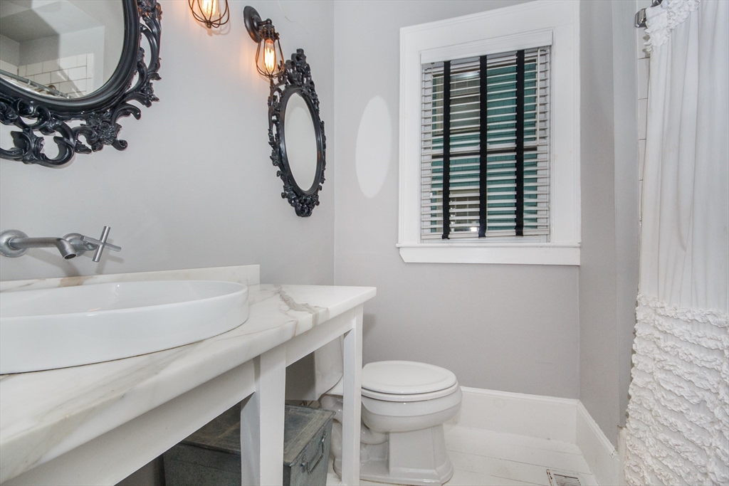 584 Centre Street Boston, MA 02130 - Photo 7 of 29 a bathroom with a sink a toilet and a mirror