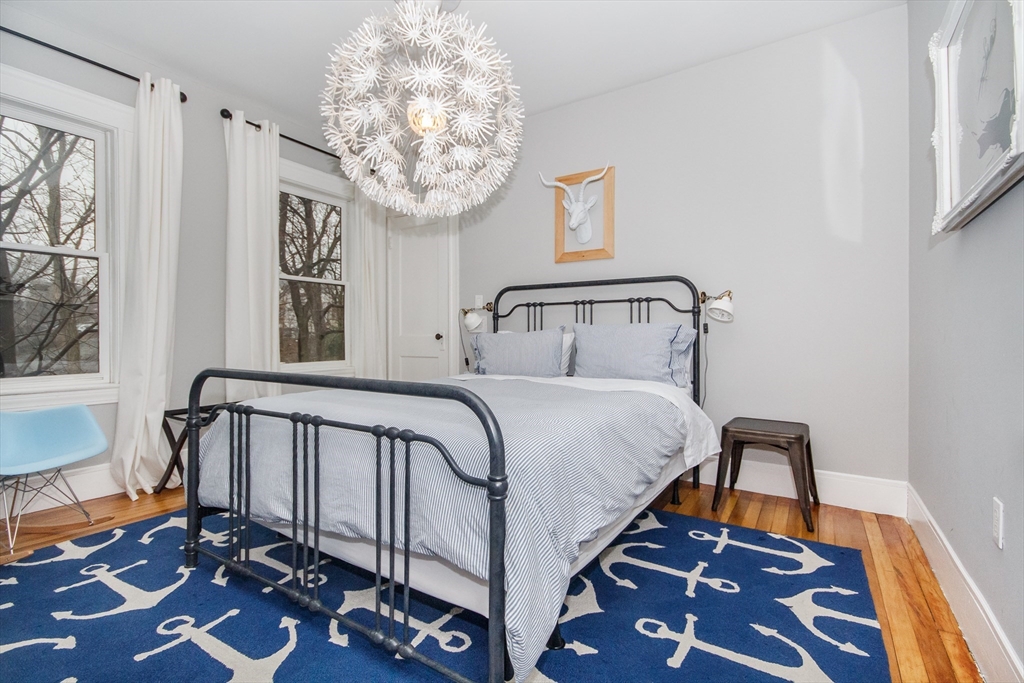 584 Centre Street Boston, MA 02130 - Photo 9 of 29 a bedroom with a bed and a chandelier