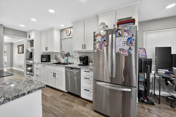 a kitchen with stainless steel appliances granite countertop a refrigerator sink and cabinets
