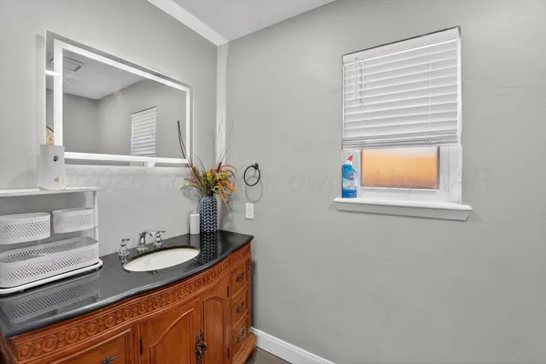a bathroom with a granite countertop sink a mirror and a window