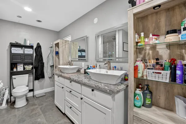 a bathroom with a granite countertop sink a toilet and a mirror