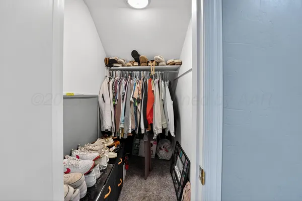 a view of walk in closet with clothes