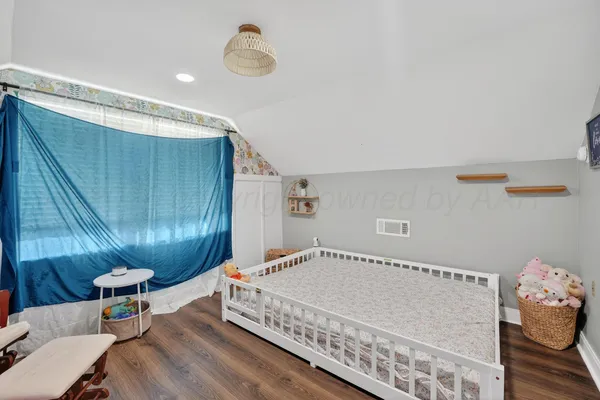 a spacious bedroom with a bed and a chandelier
