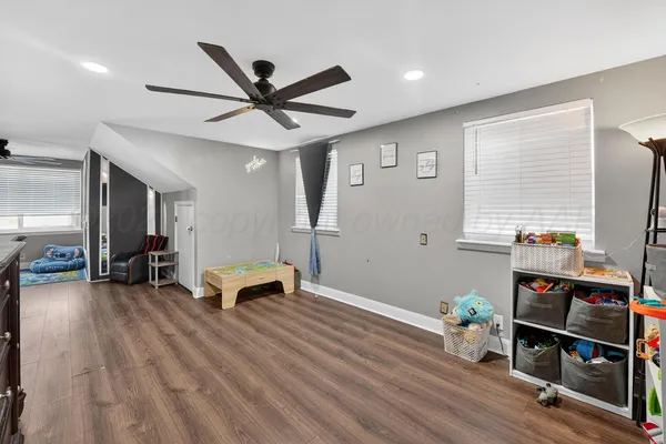 a living room with furniture and a wooden floor