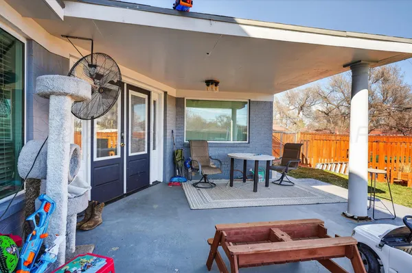a living room with furniture and a dining table next to a large window