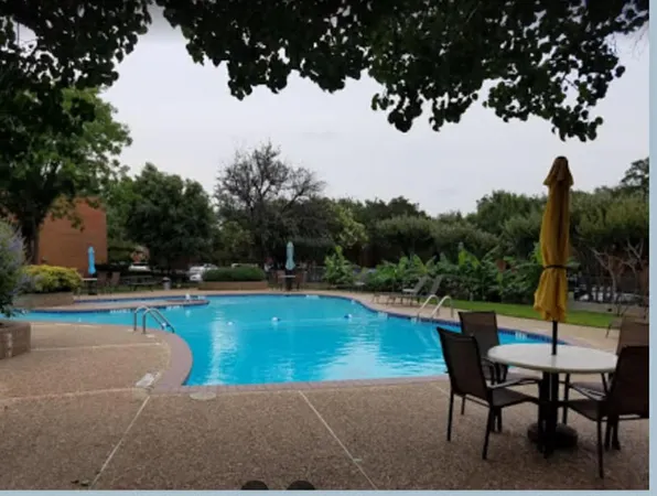 a view of a swimming pool with a patio and a garden