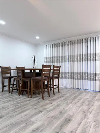 a view of a a dining room with furniture window and wooden floor