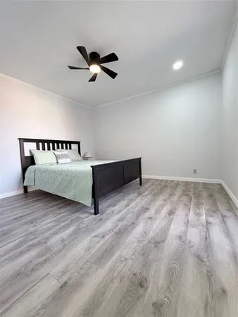 a spacious bedroom with a bed and a ceiling fan