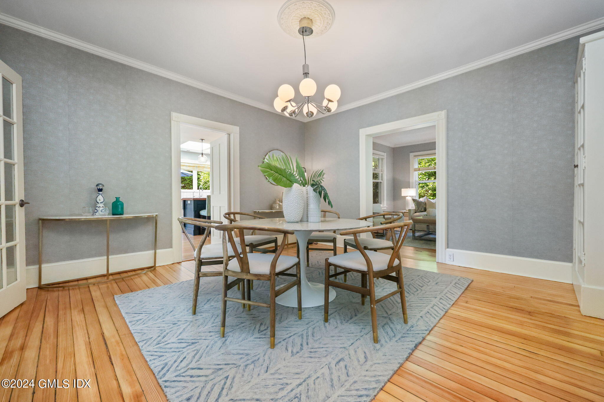 8 Hendrie Avenue Riverside, CT 06878 - Photo 11 of 33 a dining room with wooden floor a chandelier a wooden table and chairs