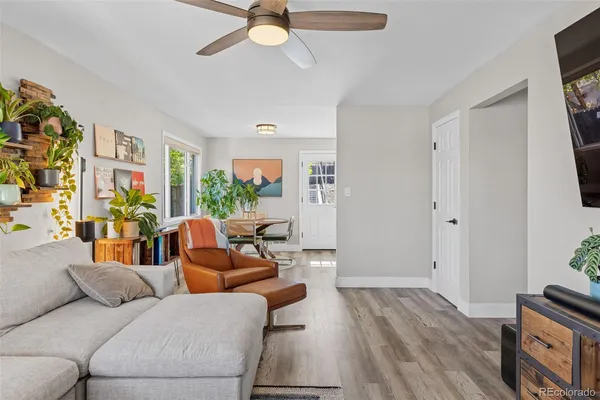 a living room with furniture and a wooden floor