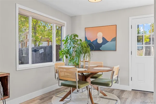 a dining room with furniture and a potted plant