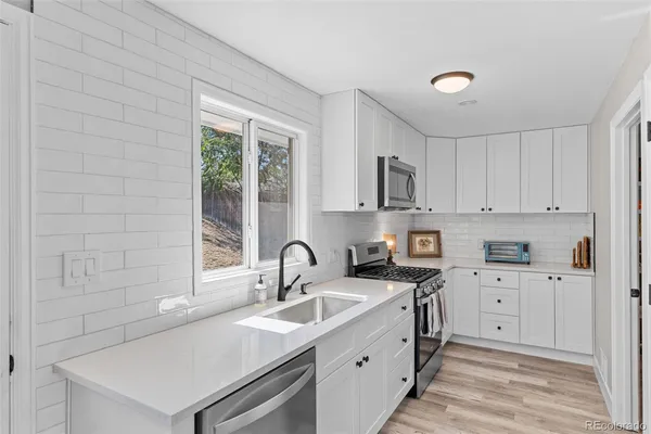 a kitchen that has a sink and a stove in it