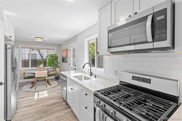 a kitchen with a stove a sink and wooden cabinets