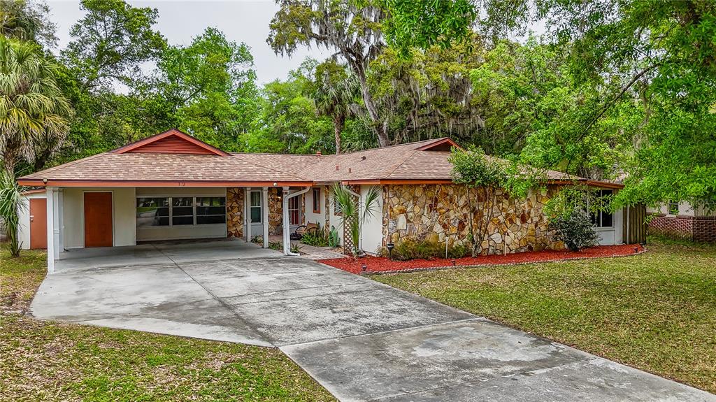 12 Spring Lake Way Ocala, FL 34472 - Photo 1 of 57 a front view of a house with a yard and potted plants