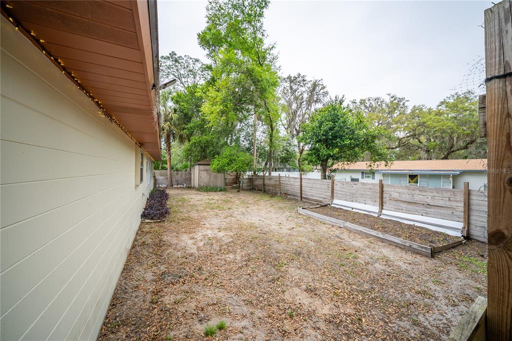 12 Spring Lake Way Ocala, FL 34472 - Photo 50 of 57 a view of a backyard with wooden fence and large trees