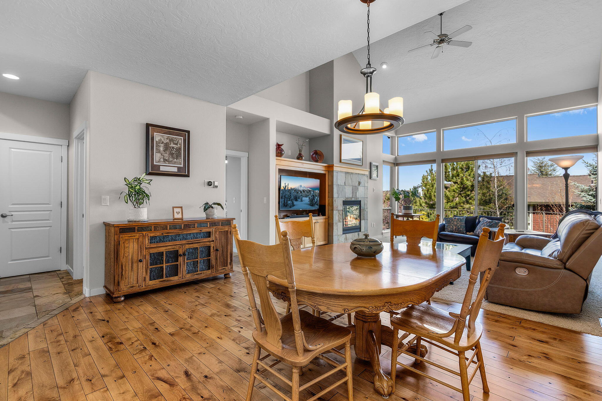 10870 Village Loop Redmond, OR 97756 - Photo 8 of 35 a dining room with wooden floor a chandelier a glass table and chairs