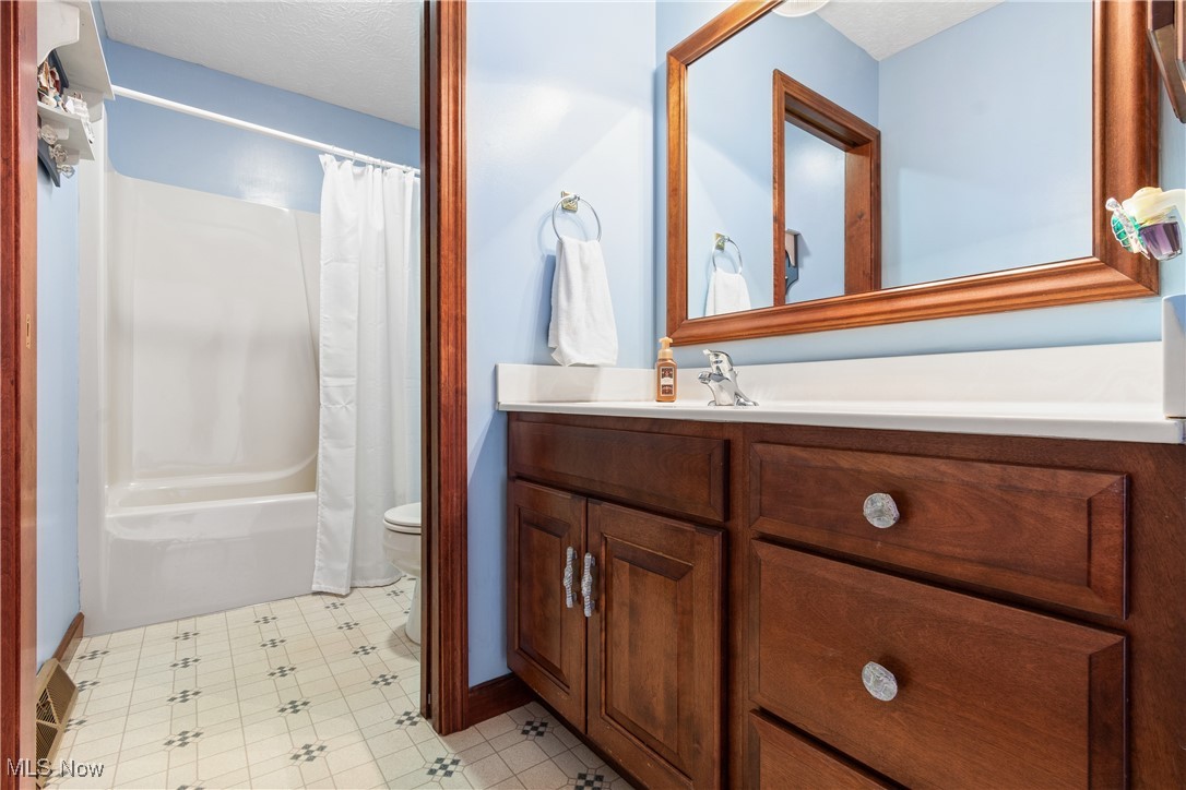 3393 Friendsville Road Wooster, OH 44691 - Photo 19 of 34 Full bath with a textured ceiling, toilet, vanity, tile patterned floors, and shower / bathtub combination with curtain