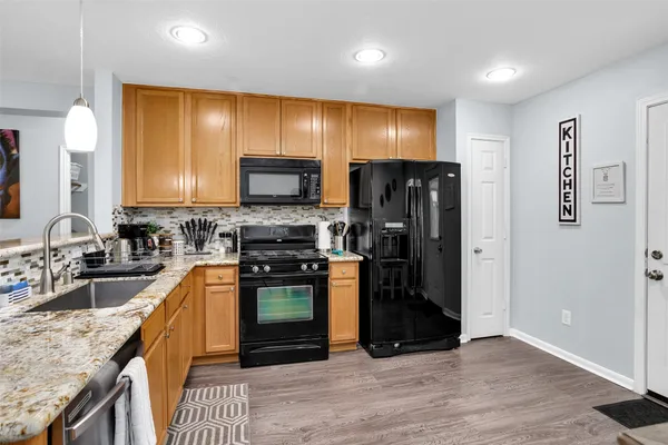 a kitchen with stainless steel appliances kitchen island granite countertop a stove a sink and a microwave