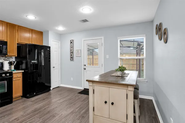 a kitchen with stainless steel appliances a stove a table and chairs