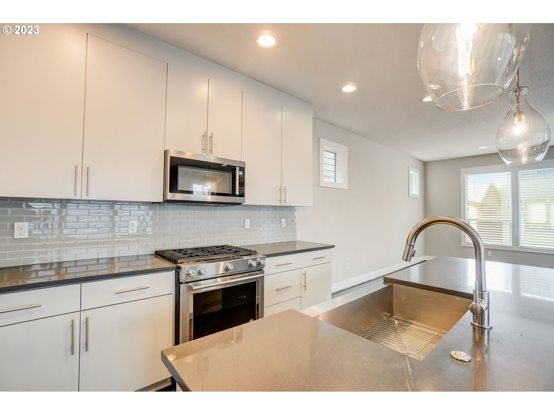 548 Southwest Chinook Terrace Portland, OR 97225 - Photo 15 of 44 a kitchen with granite countertop a stove a sink and a microwave