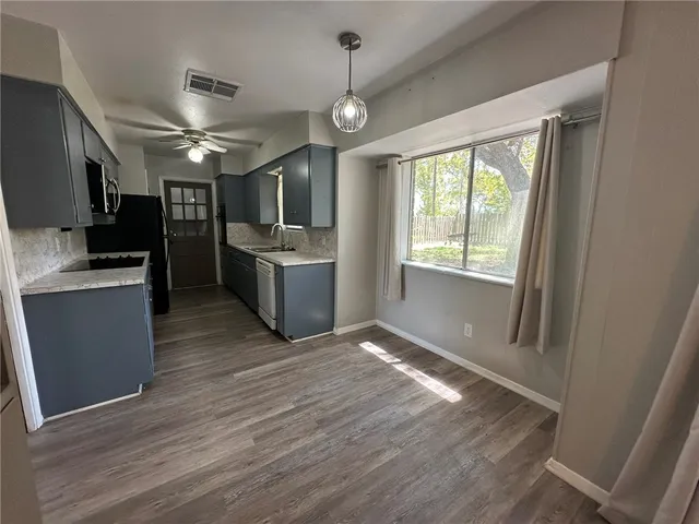 a view of a kitchen with a sink microwave and cabinets