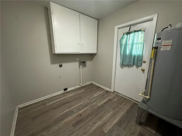 an empty room with wooden floor and mirror