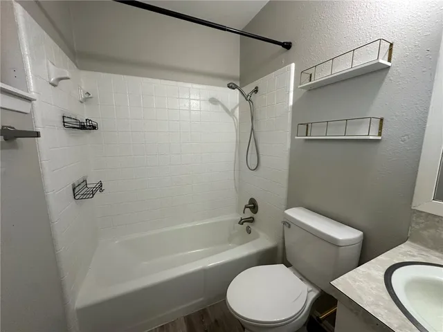 a white toilet and tub sitting next to a bathroom sink