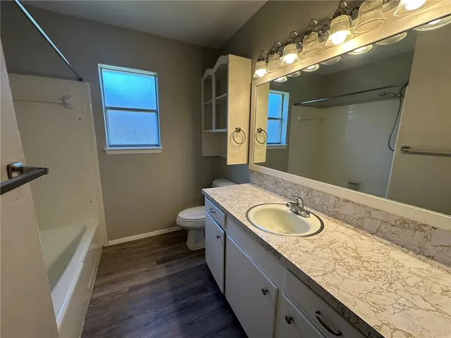 a bathroom with a granite countertop double vanity sink and mirror