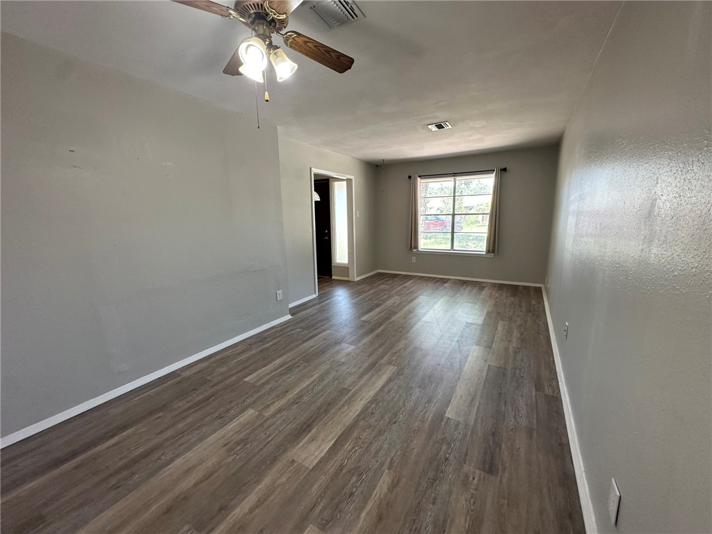 2994 Lovers Lane Ingleside, TX 78362 - Photo 7 of 39 an empty room with wooden floor chandelier fan and windows