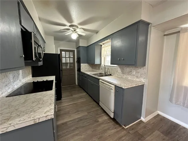 a kitchen with stainless steel appliances granite countertop a refrigerator and a sink