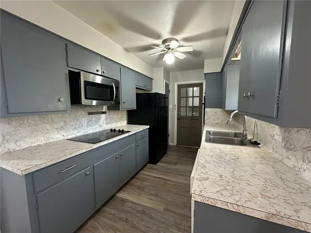 a large kitchen with kitchen island granite countertop a sink counter space and stainless steel appliances