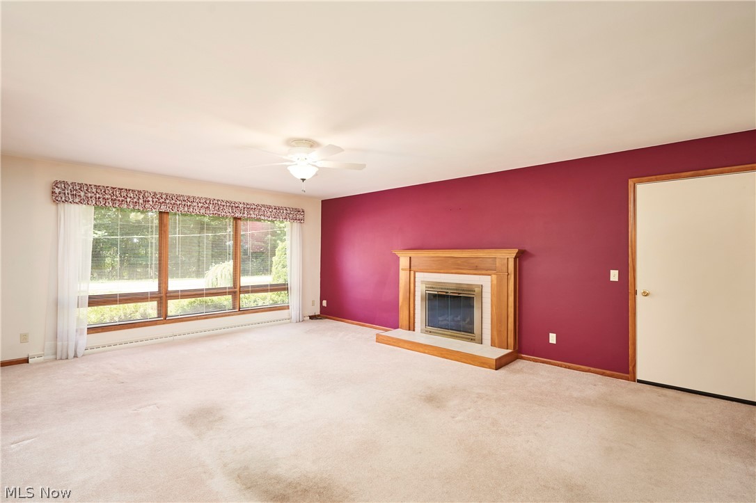 299 West Caston Road New Franklin, OH 44319 - Photo 7 of 23 Spacious living area featuring a prominent fireplace with a light wood mantel and hearth