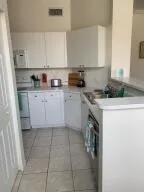 a kitchen with a sink a stove top oven and white cabinets