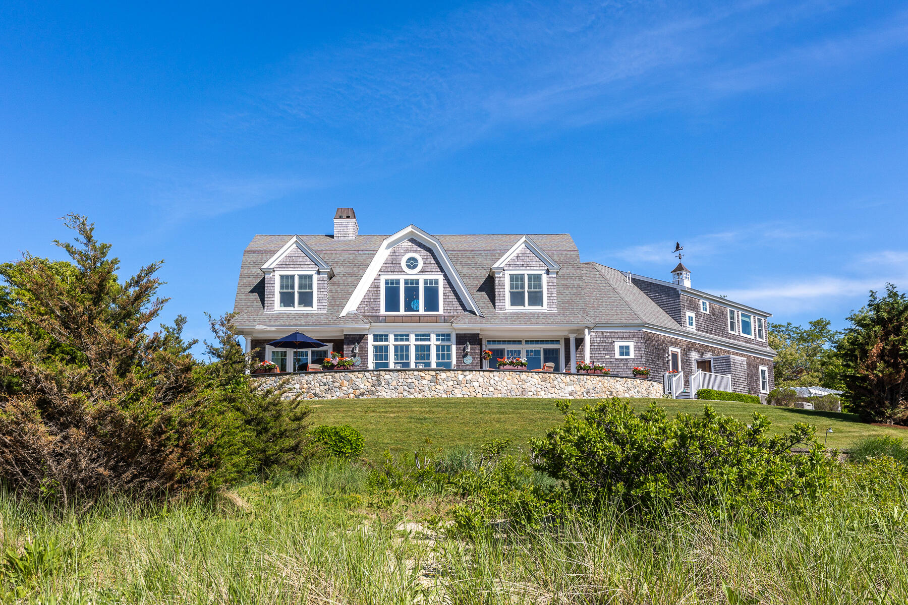 345 Robbins Hill Road Brewster, MA 02631 - Photo 25 of 95 a front view of a house with garden and swimming pool
