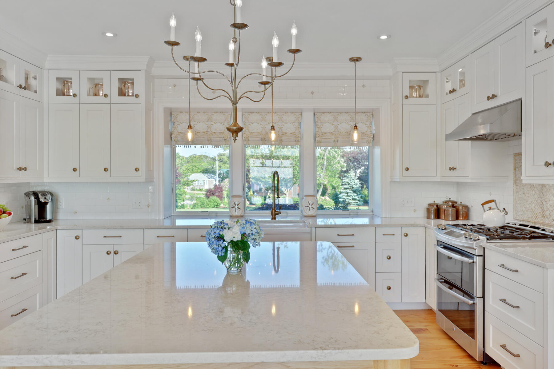 345 Robbins Hill Road Brewster, MA 02631 - Photo 43 of 95 a kitchen with stainless steel appliances granite countertop a stove a sink and white cabinets with wooden floor