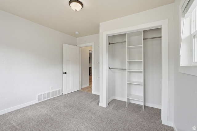 215 East 300 South Logan, UT 84321 - Photo 14 of 32 Unfurnished bedroom with light carpet and a closet