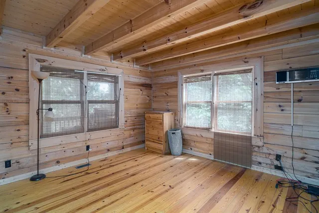 a view of empty room with a fireplace and windows