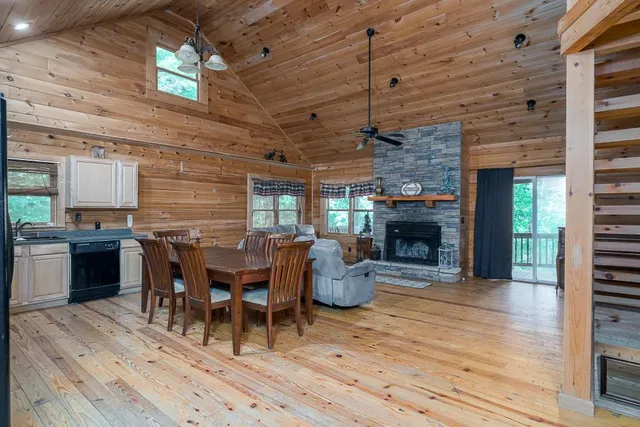 a dining room with furniture a fireplace and wooden floor