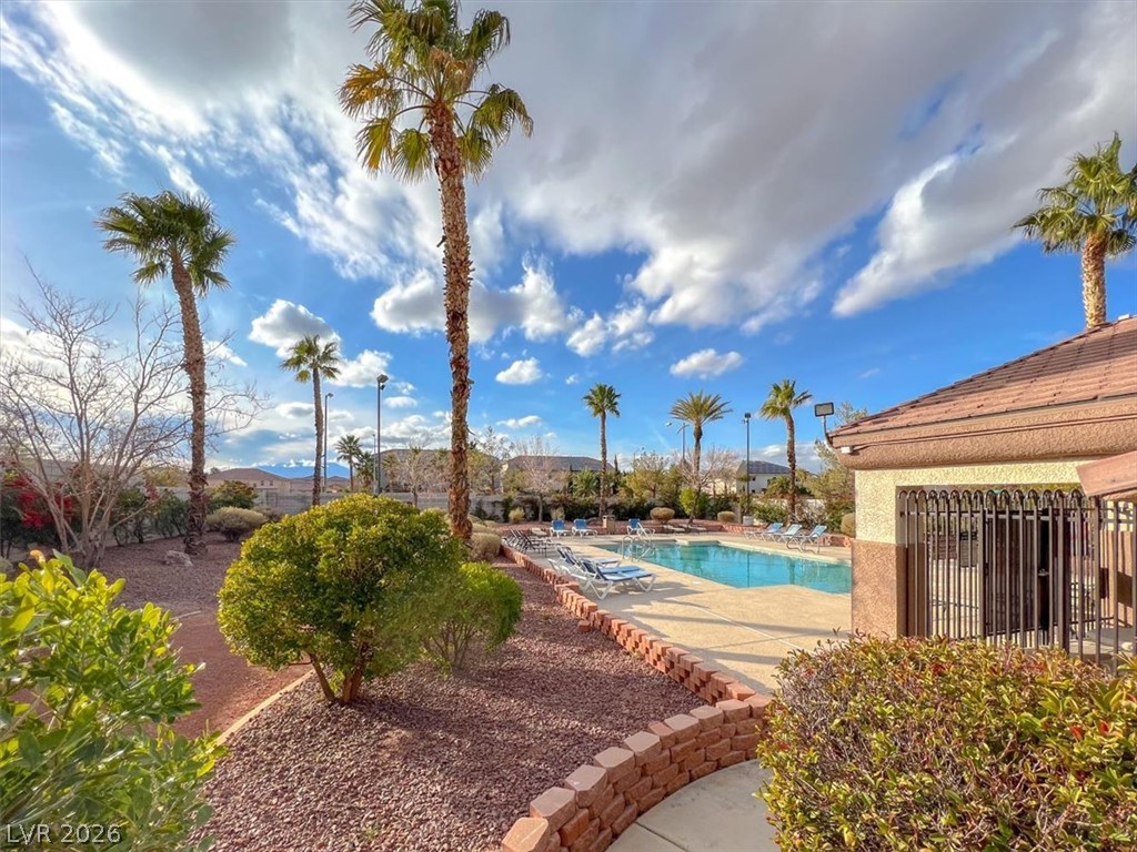 10148 Tree Bark Street Las Vegas, NV 89183 - Photo 35 of 37 A refreshing outdoor pool awaits, nestled amidst swaying palm trees and manicured landscaping.