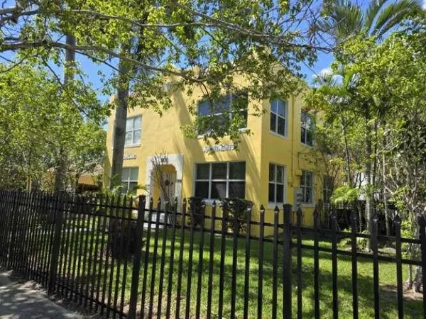 a view of a brick house with a large trees