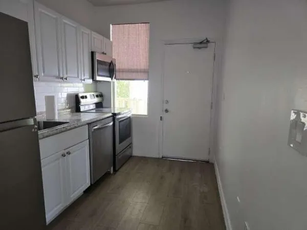 a kitchen with sink a microwave and cabinets