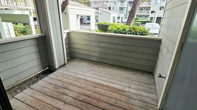 a view of a balcony with wooden floor and fence and windows