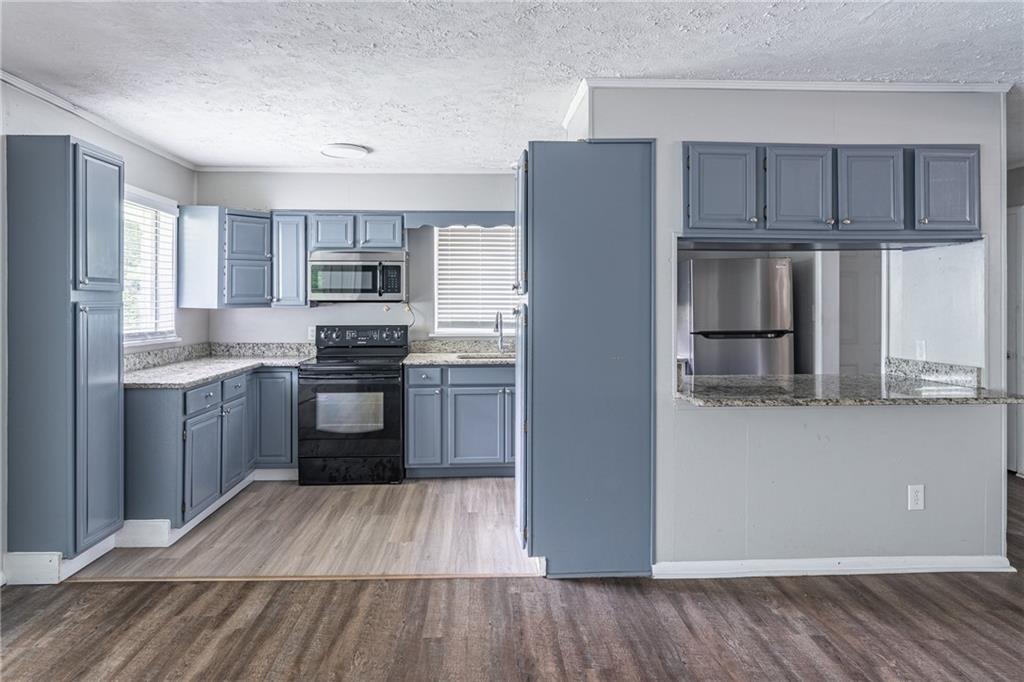 8035 Rockbridge Road Southwest Lithonia, GA 30058 - Photo 11 of 39 a kitchen with stainless steel appliances a refrigerator sink and cabinets