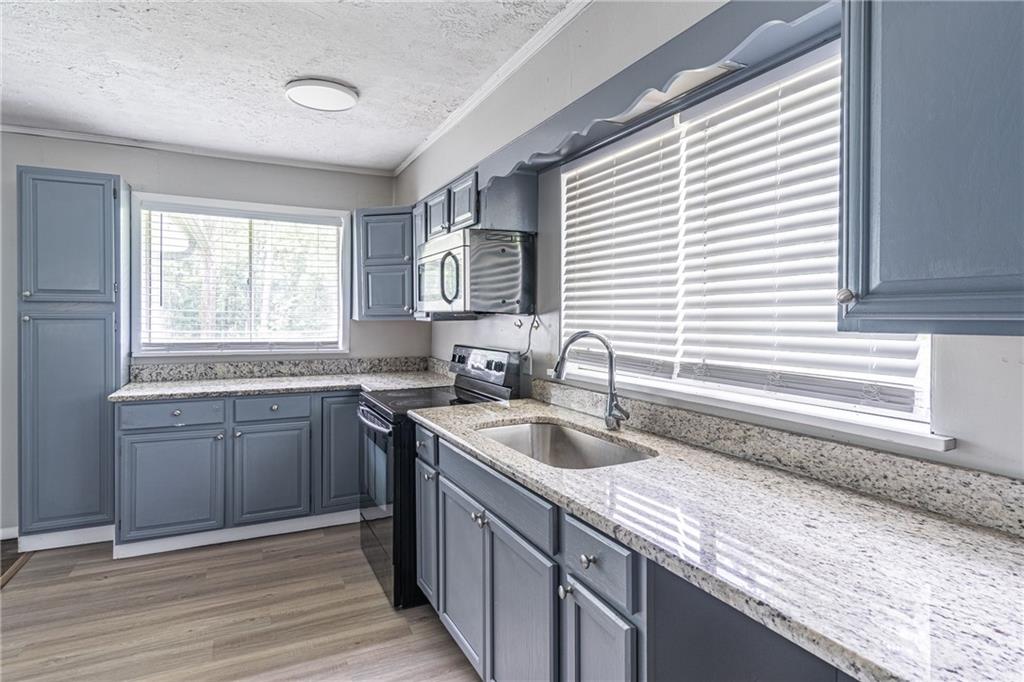 8035 Rockbridge Road Southwest Lithonia, GA 30058 - Photo 12 of 39 a kitchen with a sink cabinets and window