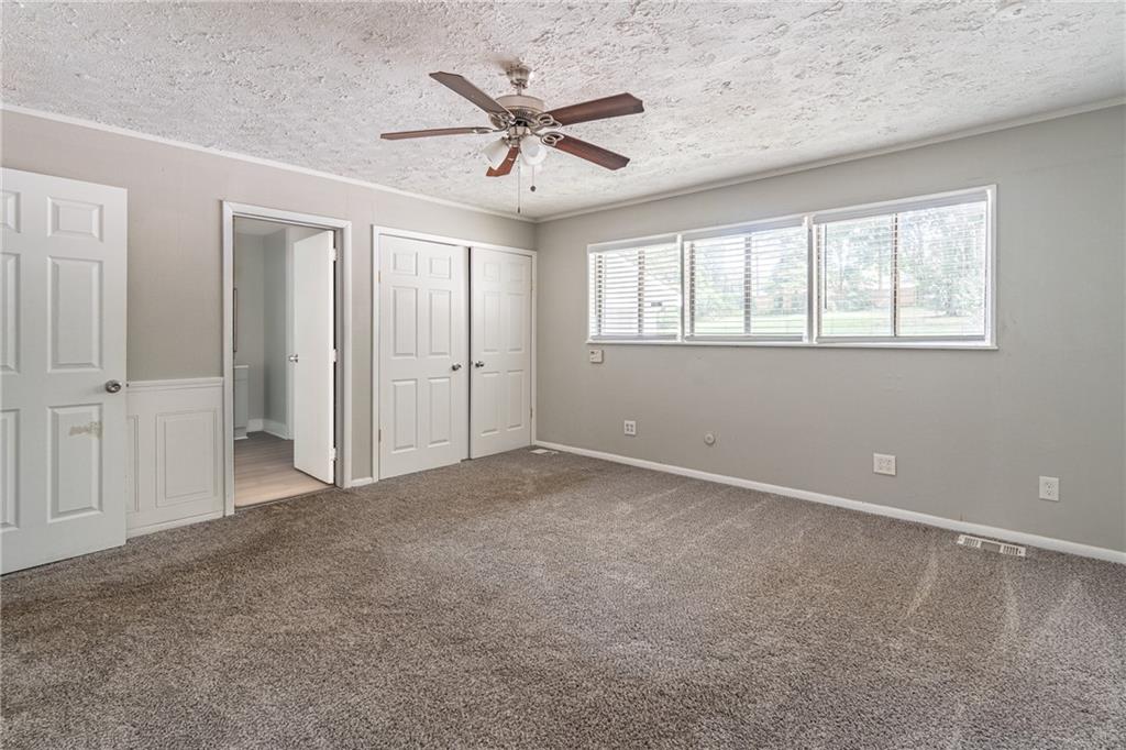 8035 Rockbridge Road Southwest Lithonia, GA 30058 - Photo 13 of 39 an empty room with ceiling fan and windows