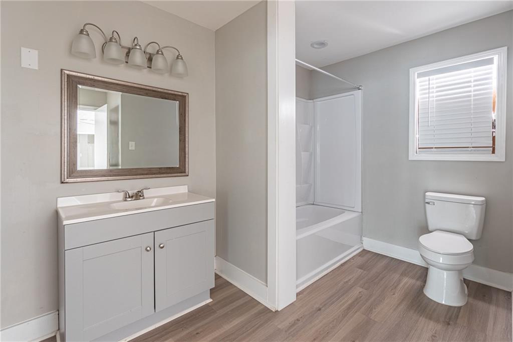 8035 Rockbridge Road Southwest Lithonia, GA 30058 - Photo 14 of 39 a bathroom with a toilet sink and a mirror
