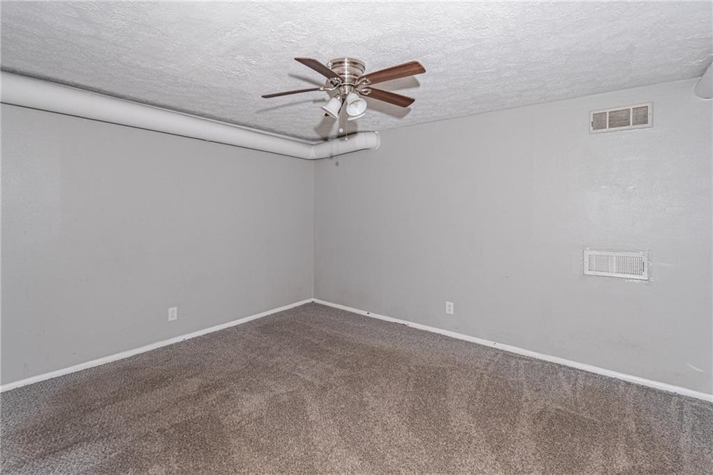 8035 Rockbridge Road Southwest Lithonia, GA 30058 - Photo 17 of 39 a view of a room with a ceiling fan and wooden floor