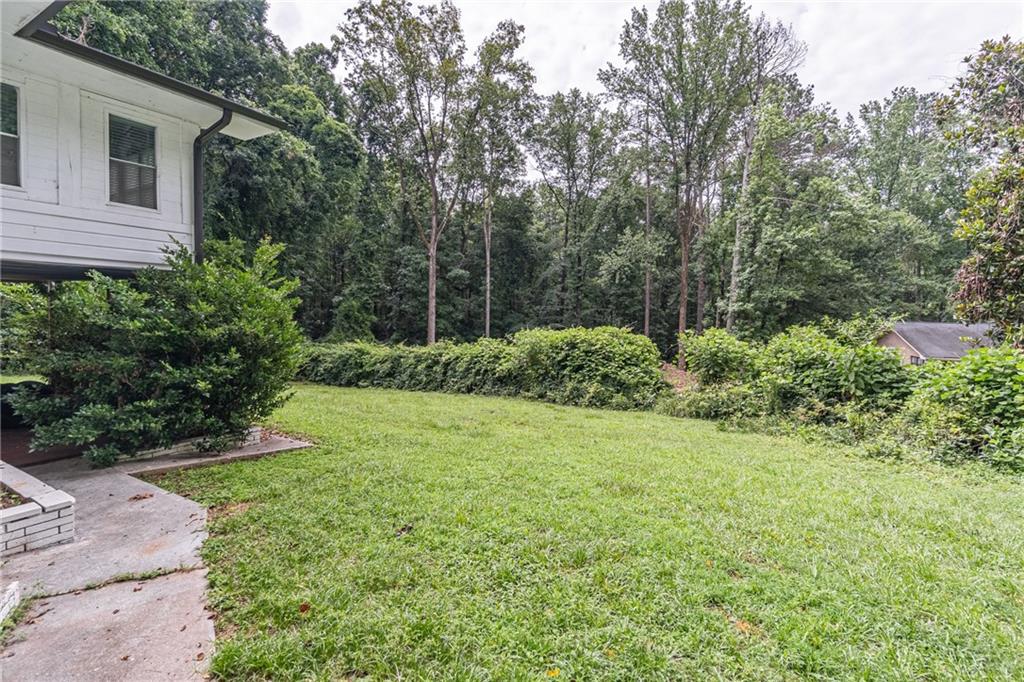 8035 Rockbridge Road Southwest Lithonia, GA 30058 - Photo 22 of 39 a view of a backyard with potted plants and large trees